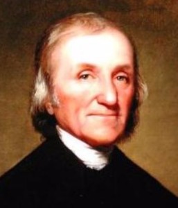 Beige-skinned man with sand-and-gray colored, shoulder-length hair, dressed in old-fashioned black jacket and white cravat