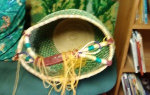 Multi-colored basket turned on its side with yarn spilling out of it